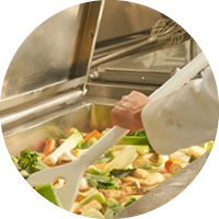 Koch rührt Gemüse in einem großen Topf um. Koch rührt Gemüse in einem großen Topf um.